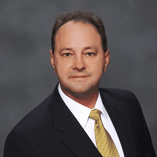 Professional headshot of a man in a suit and tie.