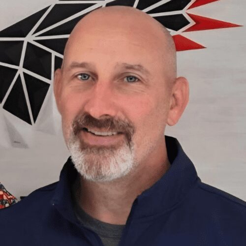 Smiling bald man with trimmed gray beard